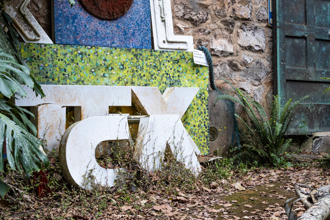 a dilapidated toilet in a dirty yard